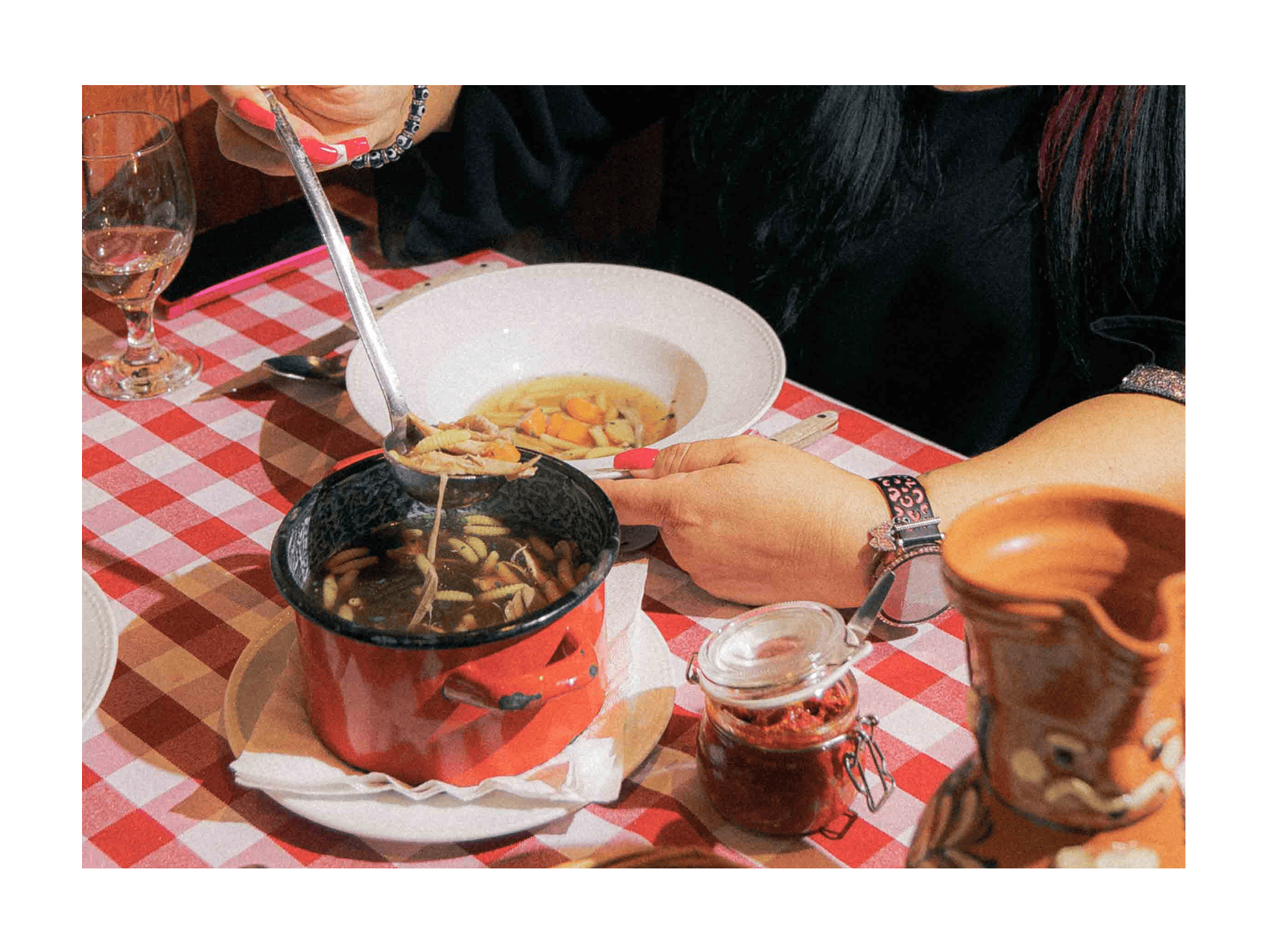 Látható egy magyar étterem asztala, ahol egy gazdag magyar leves és különféle ízletes ételek várják a vendégeket, autentikus magyar konyha a Nosztalgia Étteremben.