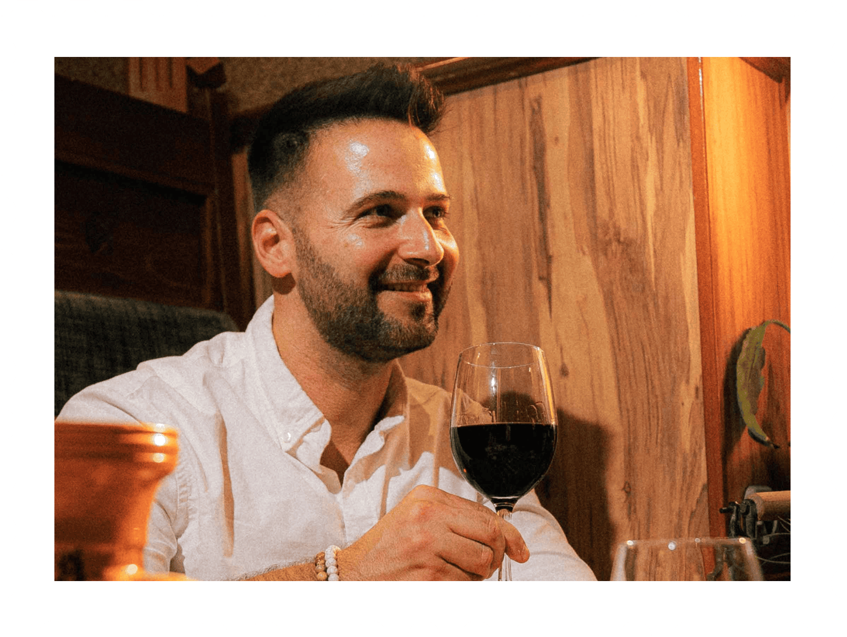 Személy pohárral borozik egy hangulatos Nosztalgia Étterem belső térben.